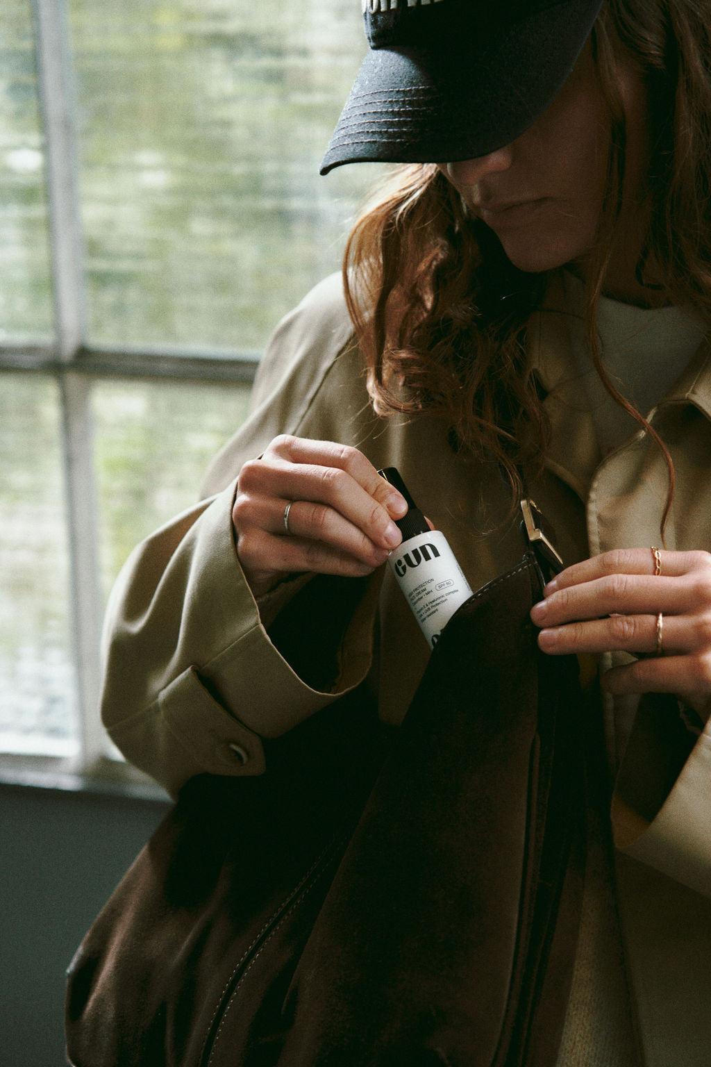 Person holding a white Gun Ana bottle outdoors