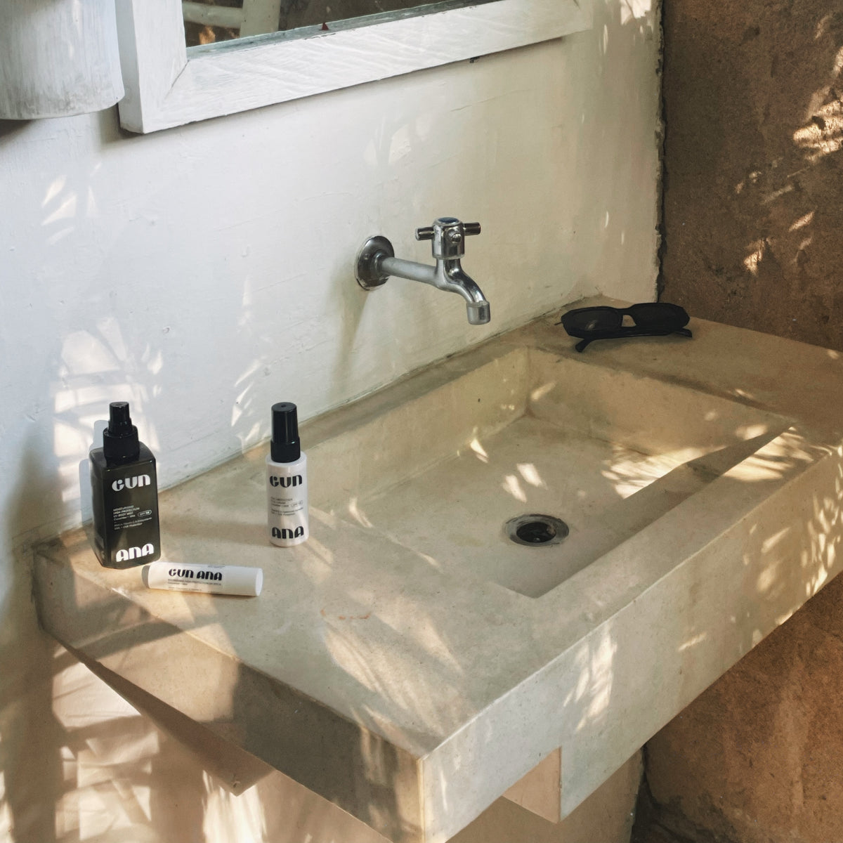 Gun Ana skincare bottles beside a bathroom sink