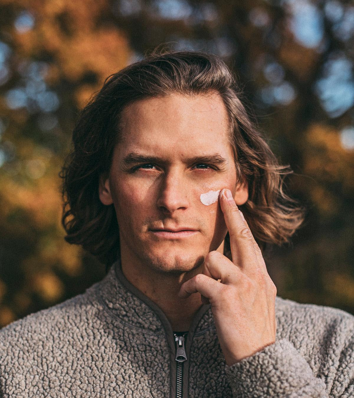Person applying cream to the face outdoors